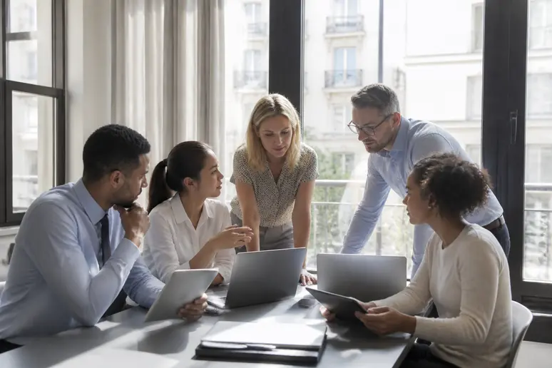 Professionnels français analysant des données et personnalisant des stratégies d'emailing lors d'une réunion dans un bureau moderne.