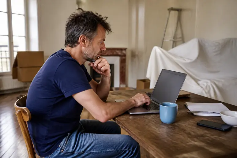 Locataire consultant ses finances sur un ordinateur portable pendant des travaux impactant son logement.