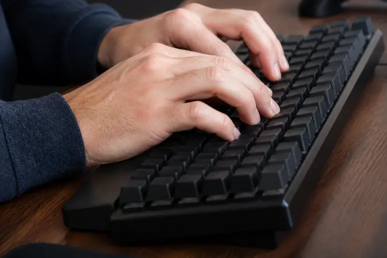 Saisie attentive des identifiants professionnels sur un clavier pour accéder au portail RH