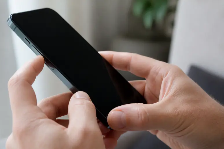 Mains appuyant sur les boutons latéraux pour redémarrer un iPhone sans tactile