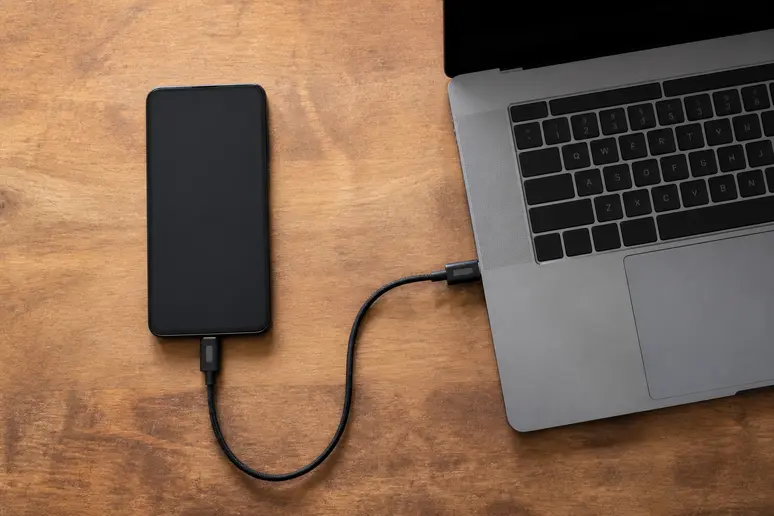 Smartphone relié par câble à un ordinateur pour éteindre l'appareil sans écran tactile