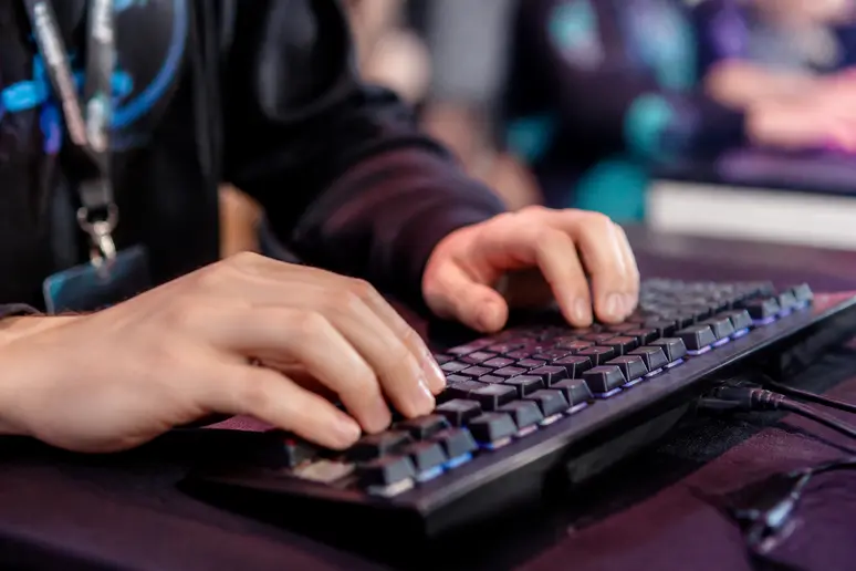 Gros plan sur des mains utilisant un clavier mécanique pendant la diffusion en direct du tournoi